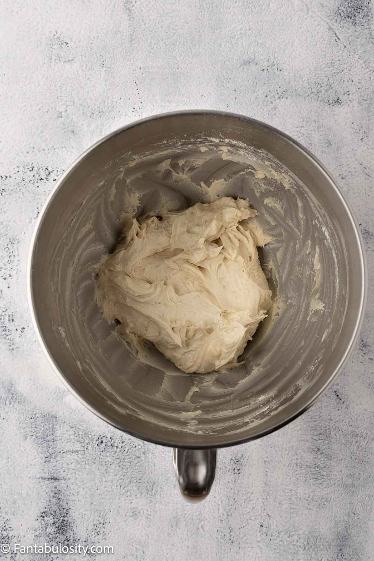 Butter and brown sugar mixed together in mixing bowl for cake frosting.