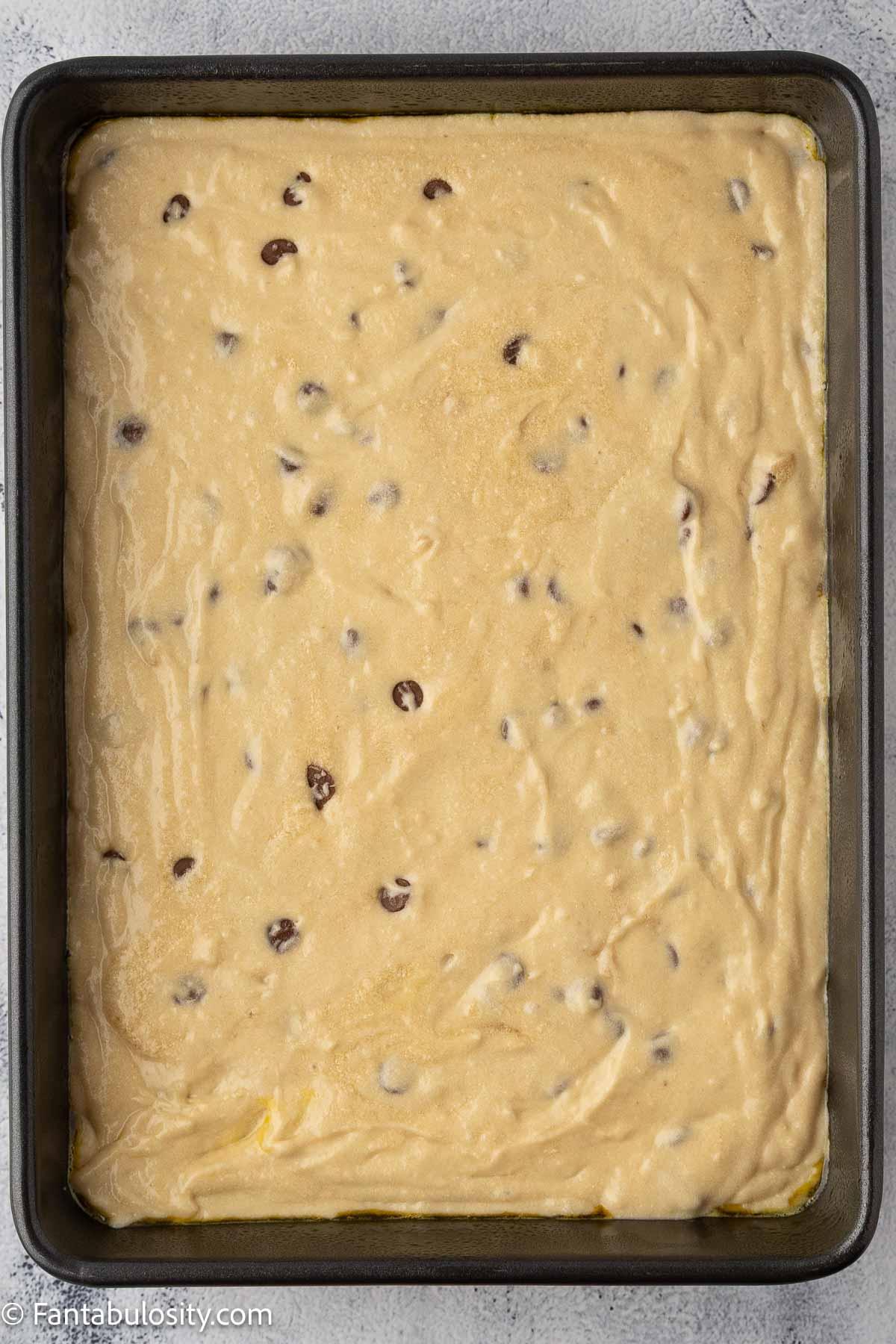 Chocolate chip cake batter poured in to 9x13 baking dish.