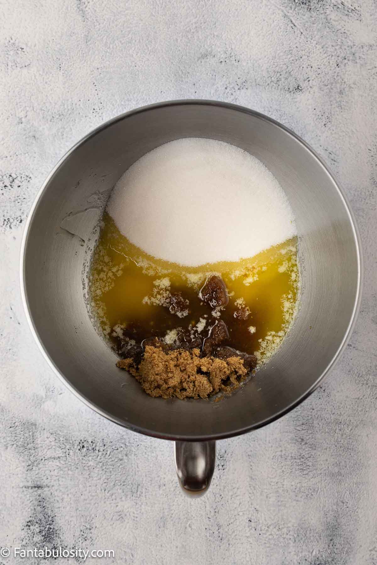 Browned butter mixed with different sugars in mixing bowl for chocolate chip sheet cake.