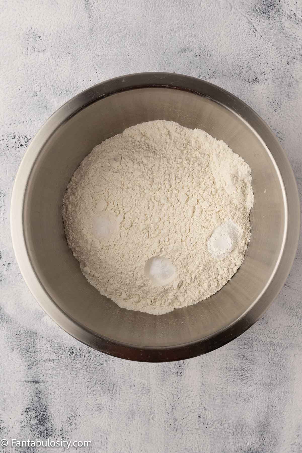 Dry ingredients like flour and salt in mixing bowl for cake recipe.
