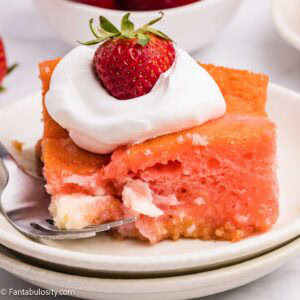 A slice of strawberry earthquake cake on a plate with fork.