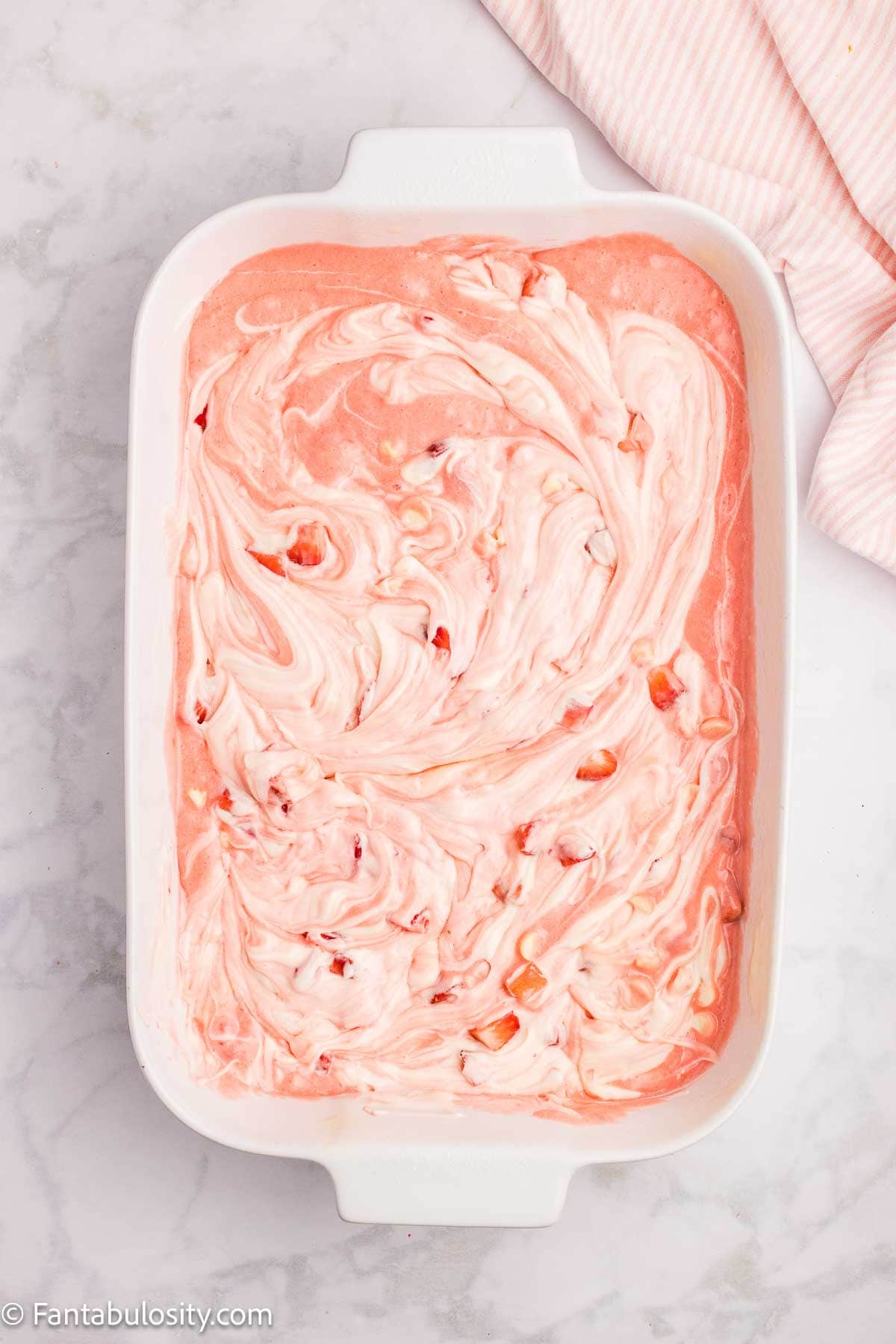 Cream cheese mixture added to strawberry cake mix batter in 9x13 baking dish.