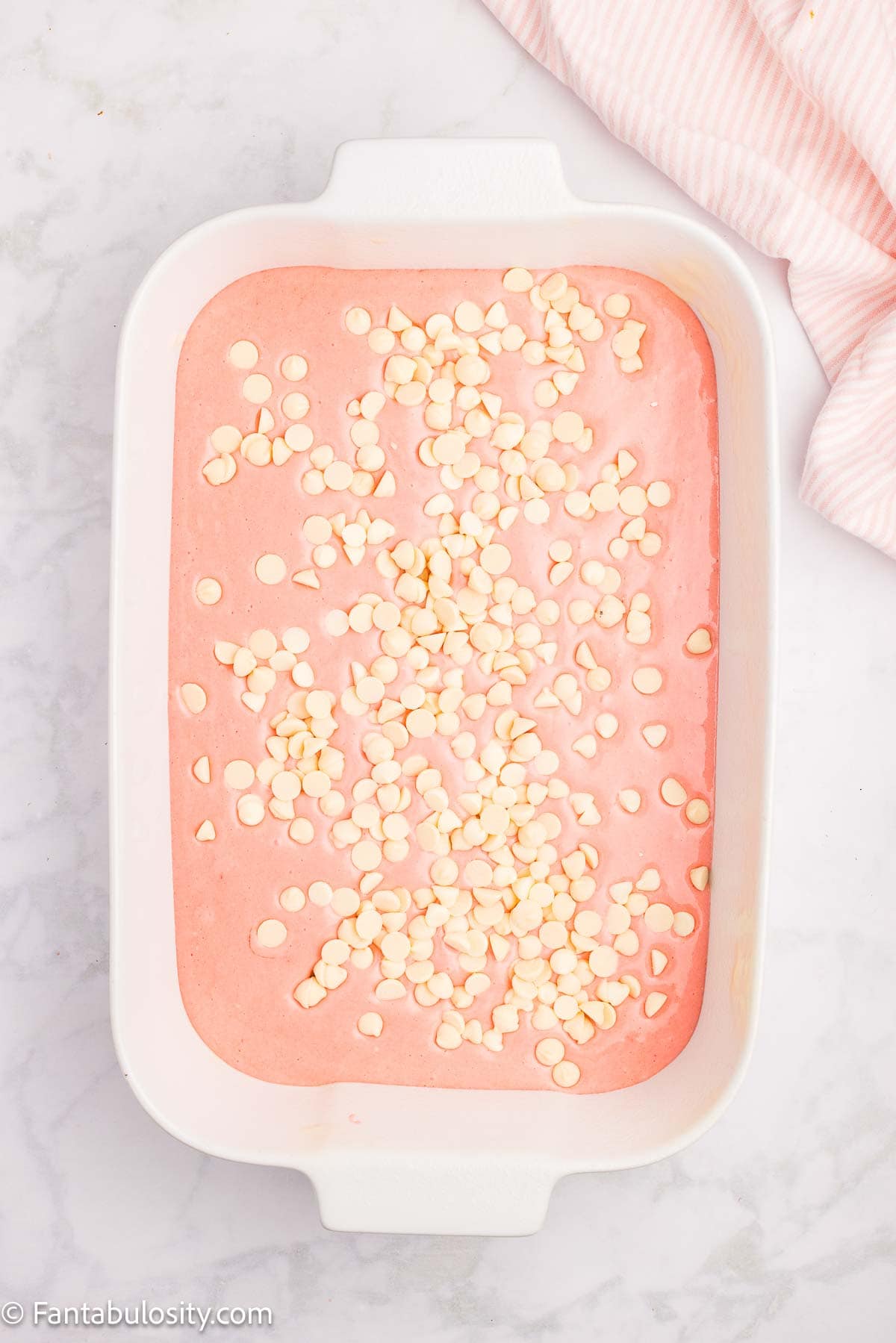 White chocolate chips poured on top of cake batter.