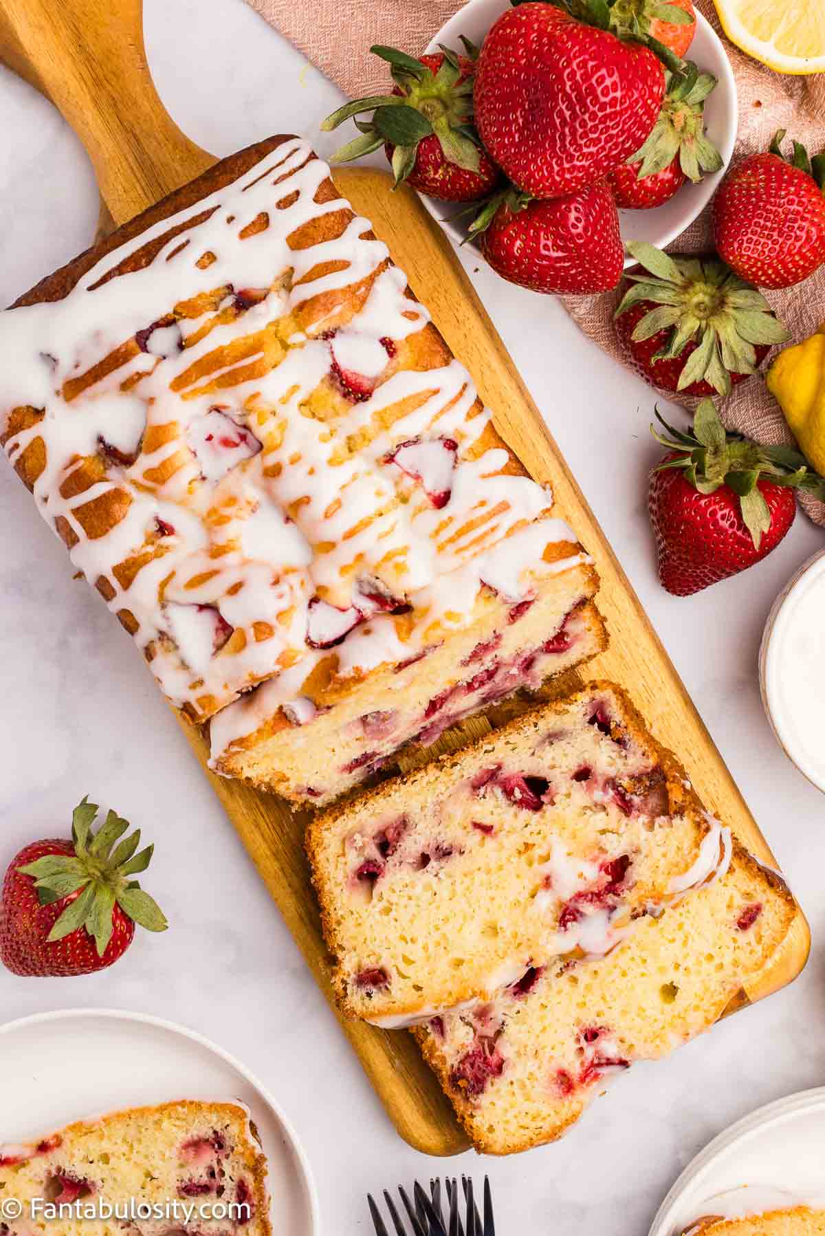 Baked strawberry lemonade bread, drizzled with lemon glaze.
