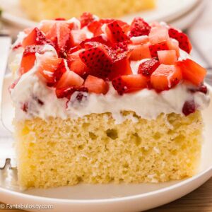 A slice of strawberry shortcake sheet cake on a round plate.