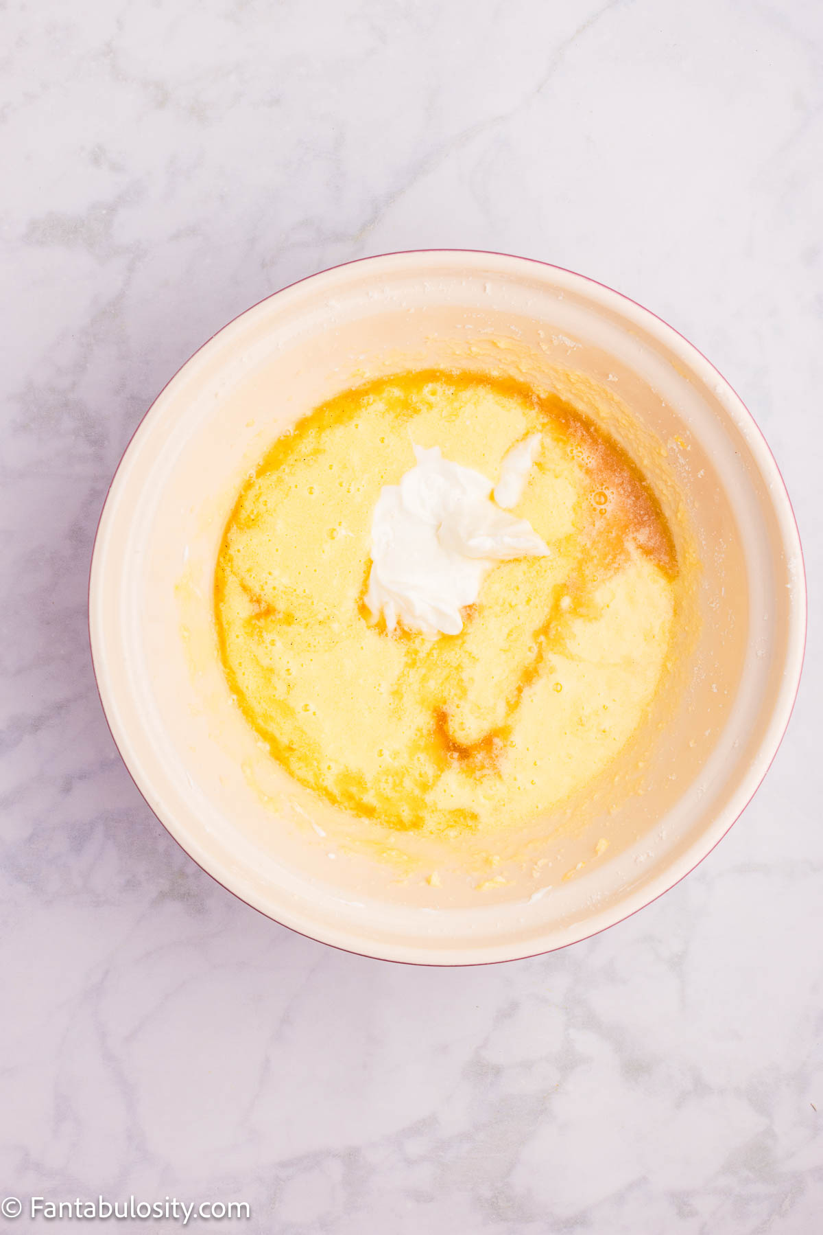 Greek yogurt and vanilla added to butter and sugar in mixing bowl.