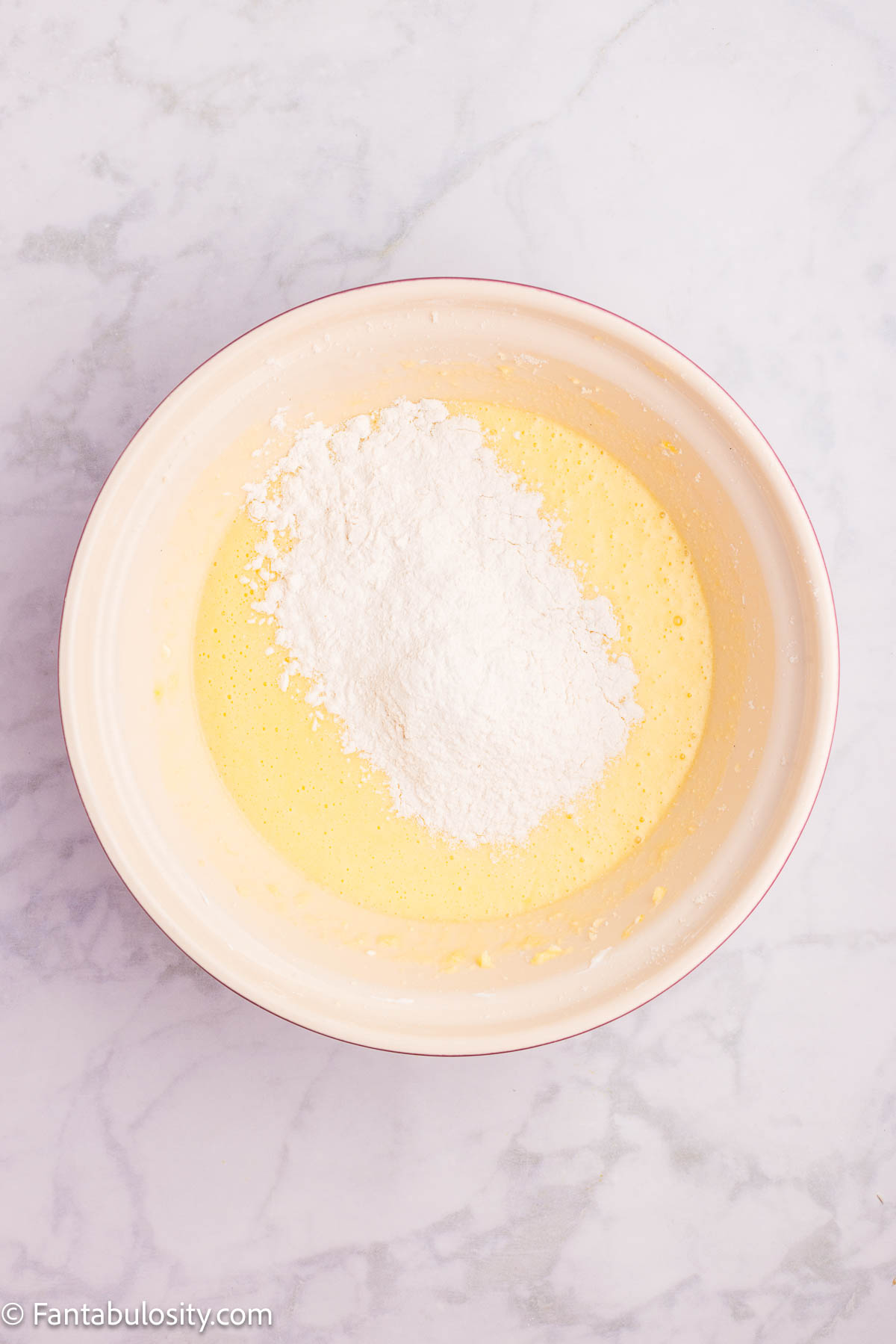 Dry ingredients added to wet mixture in mixing bowl.