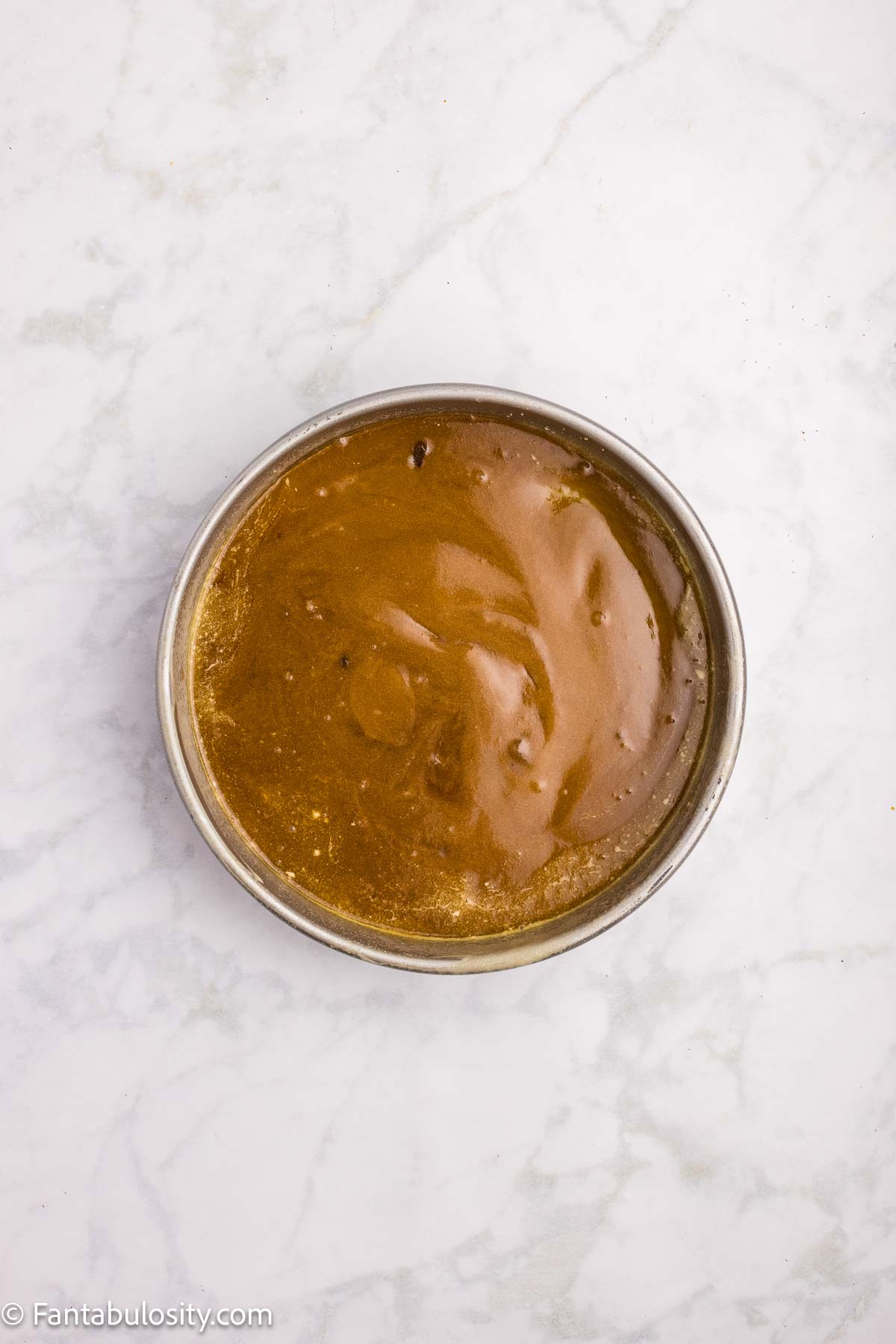 Melted butter, salt and brown sugar added to round cake pan.