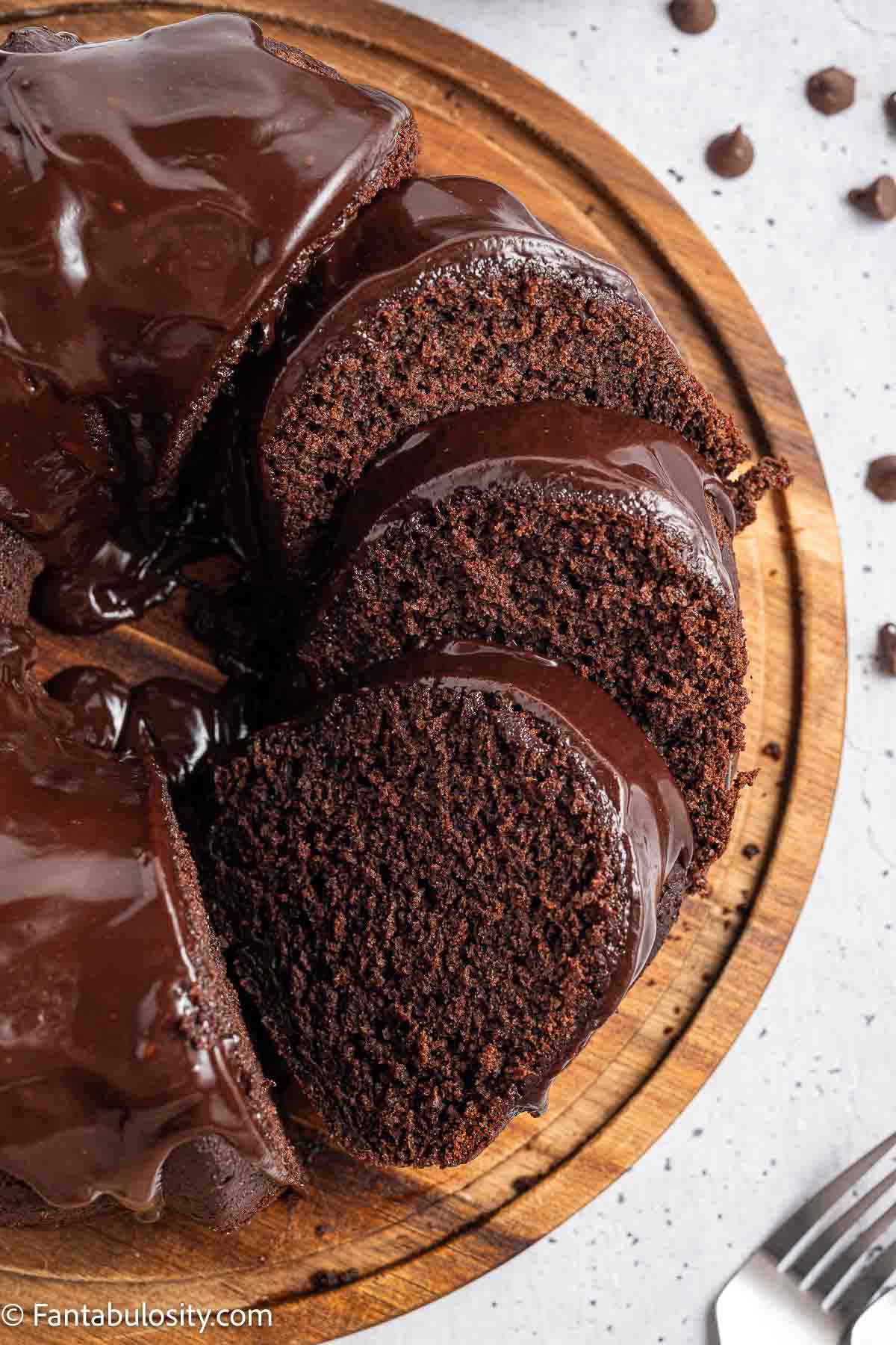 A sliced chocolate brownie cake on cake stand.