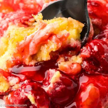 Cherry cheesecake dump cake being scooped out of a dish.