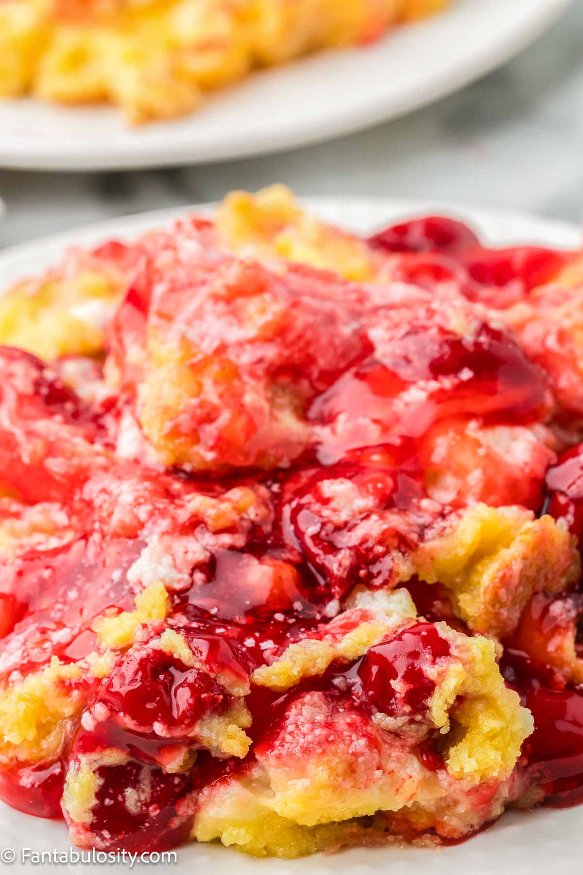 Cherry cheesecake dump cake serving on a small plate.
