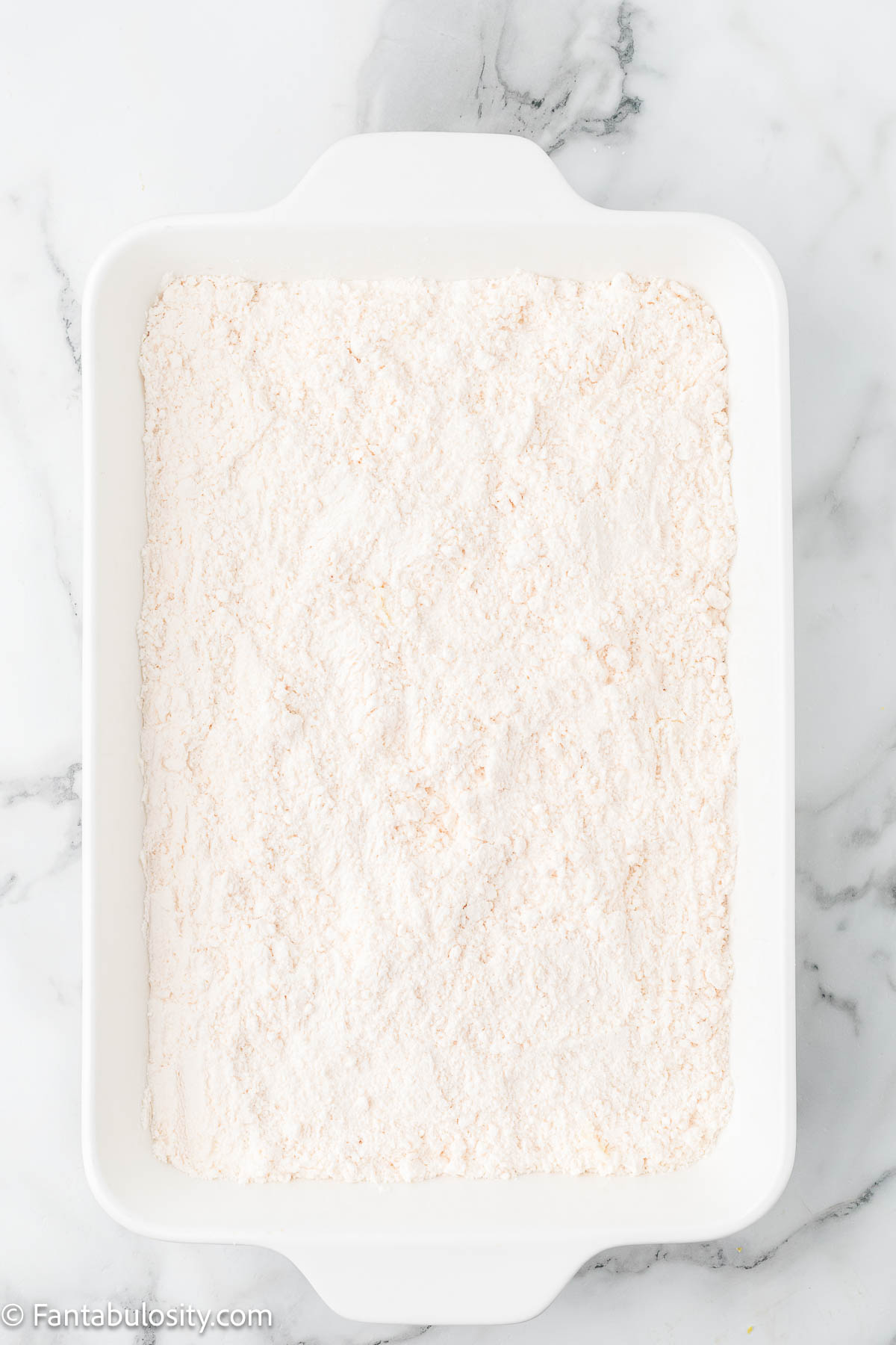 Dry cake mix sprinkled over the top of cherry cheesecake dump cake.