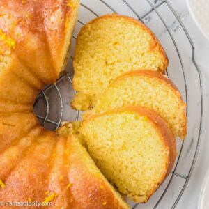 Orange juice cake sliced on a cake stand.