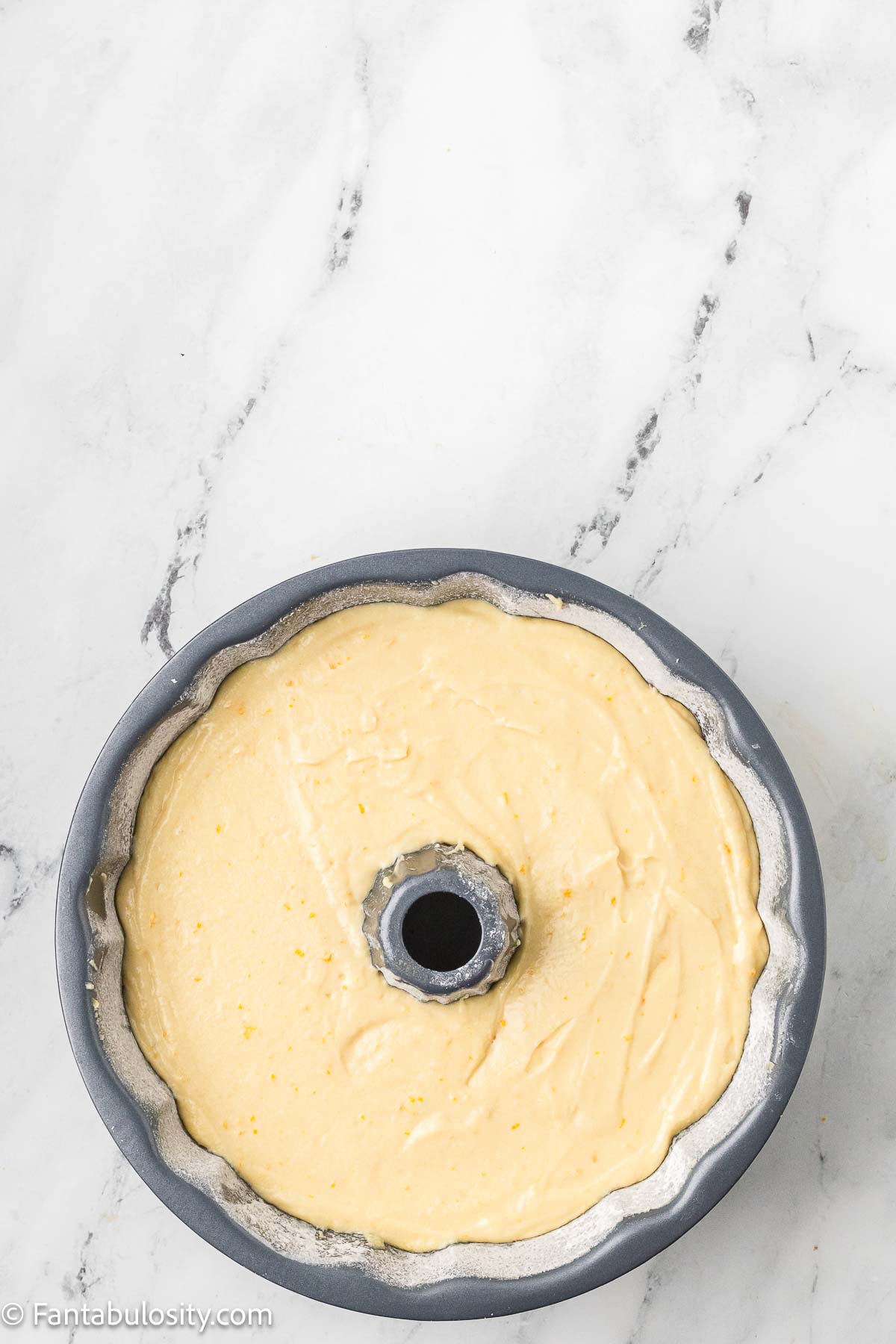 Orange juice cake batter poured in to bundt pan.