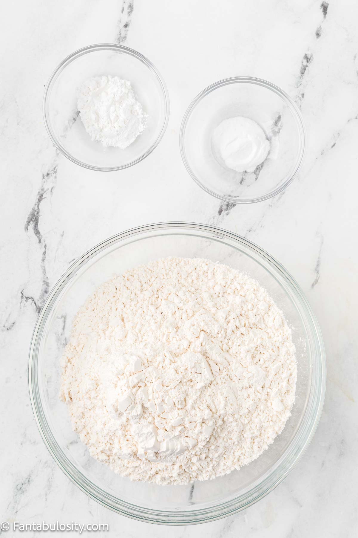 Dry ingredients in mixing bowls on counter.