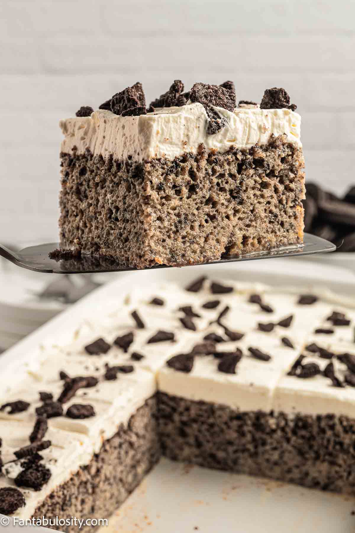A slice of Oreo Tres Leches cake on a spatula.