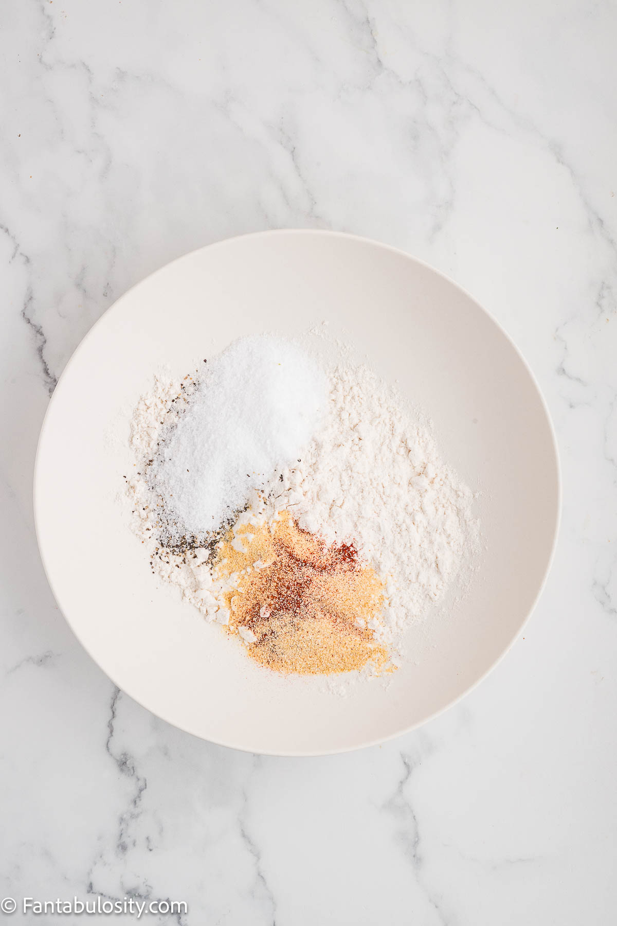 Flour and spices mixed in mixing bowl.