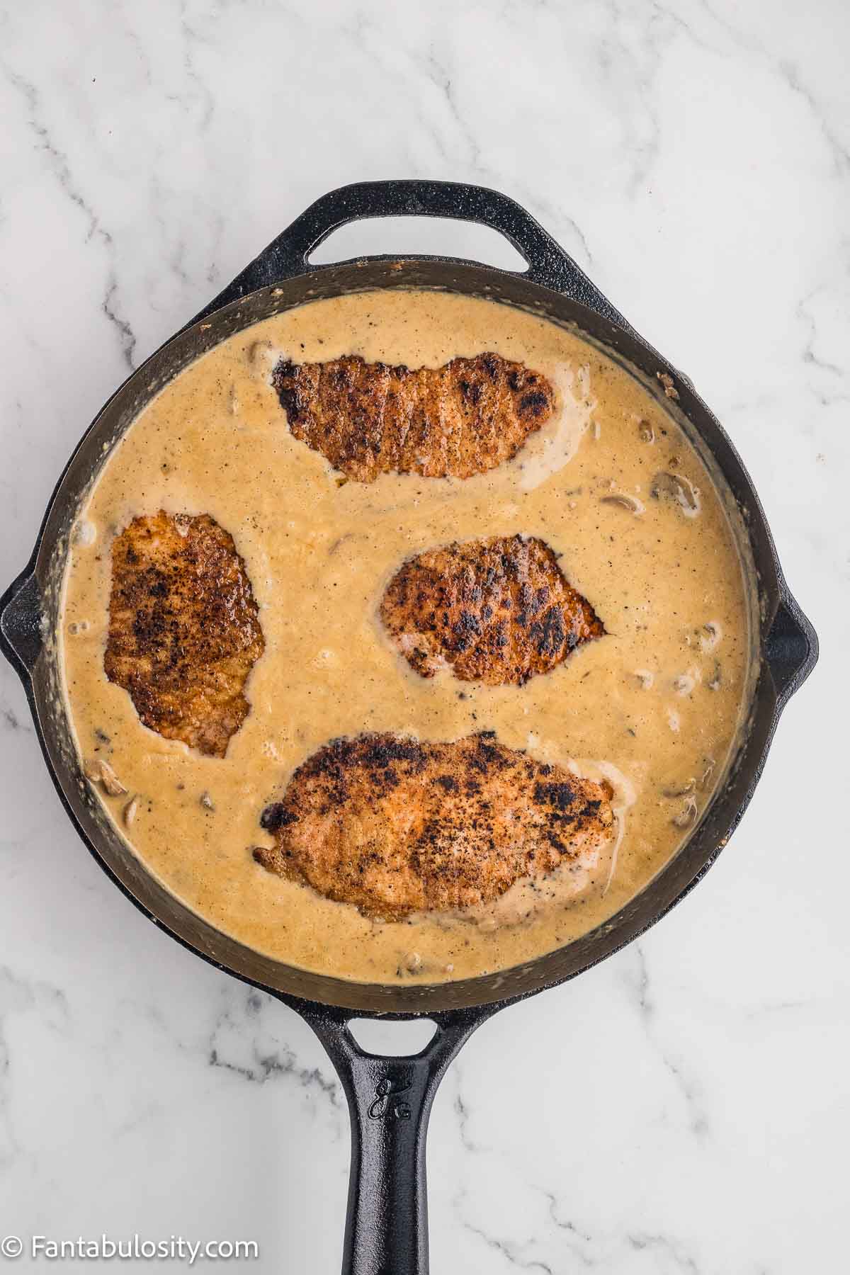 Cooked pork chops added to skillet and gravy.