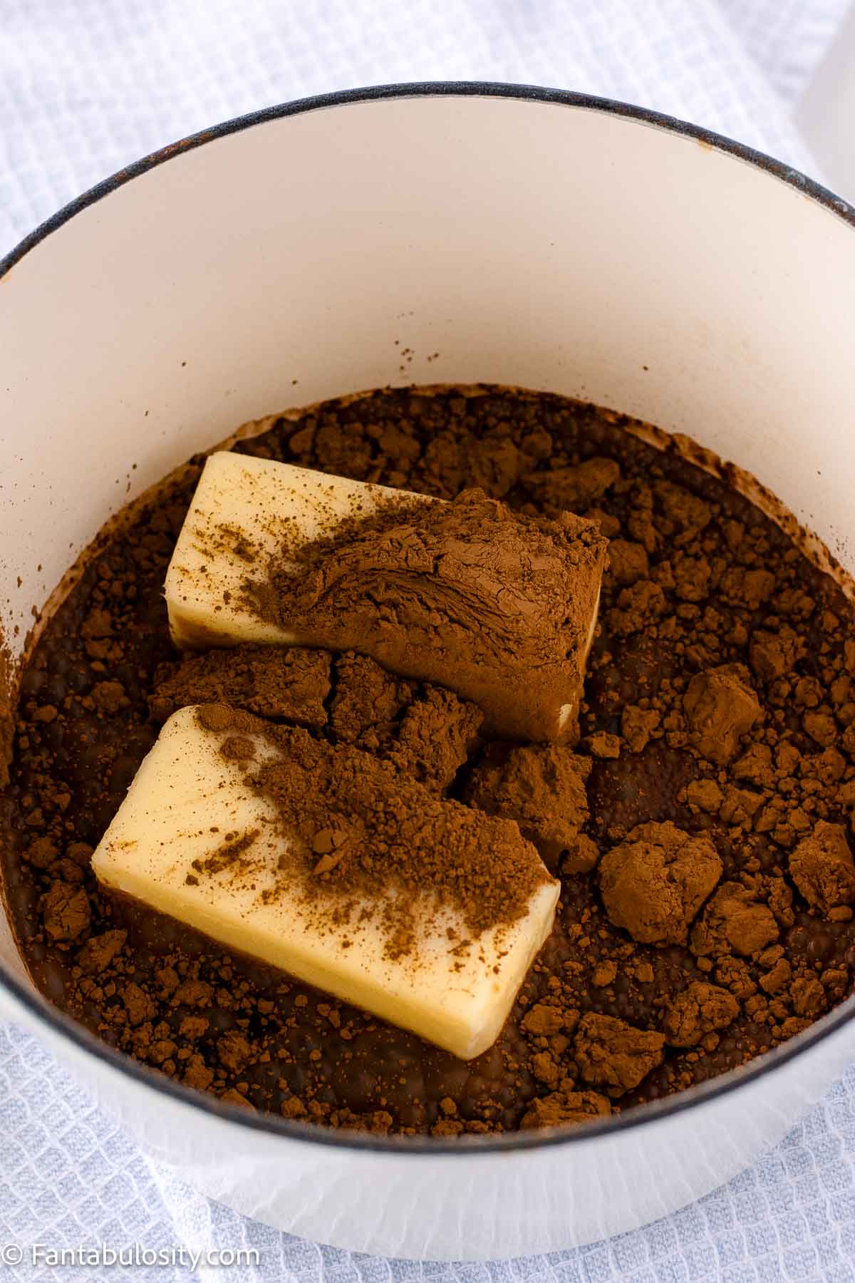 Butter, cocoa and Coca Cola in a saucepan.