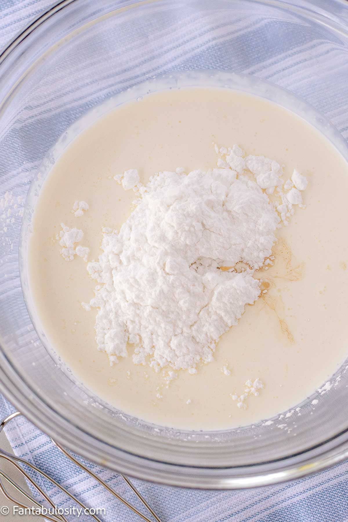 Heavy cream, powdered sugar and vanilla in a mixing bowl to make homemade whipped cream.