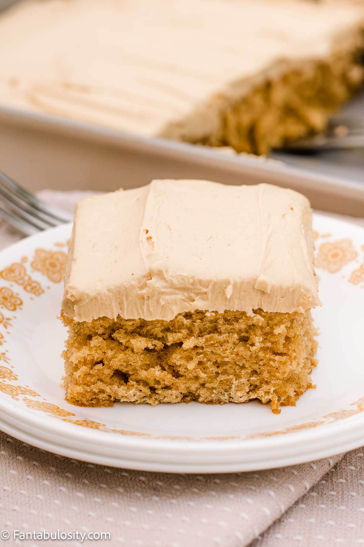 A slice of peanut butter cake on a round vintage plate.