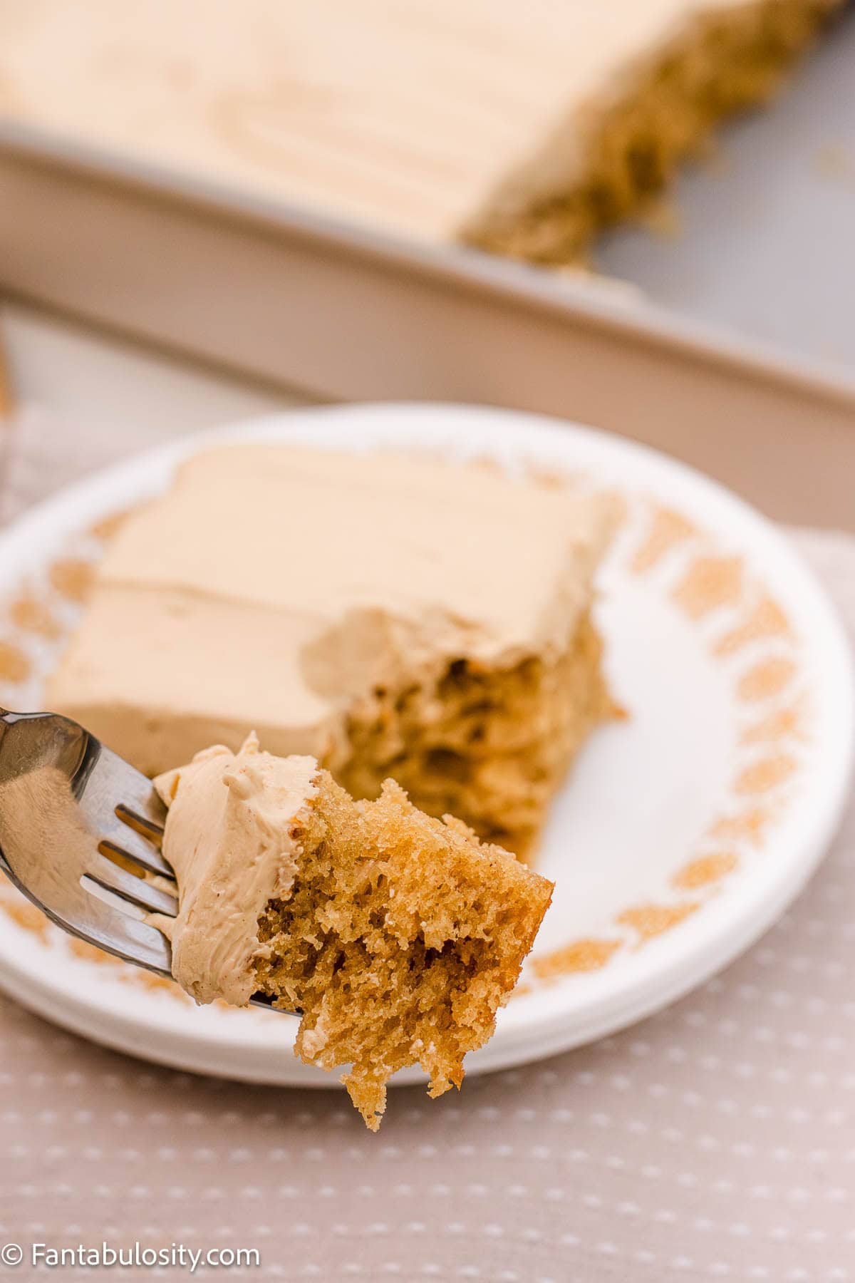 A slice of peanut butter cake with a fork taking a bite out.