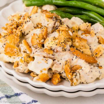 Poppy Seed Chicken Casserole serving on a plate, next to green beans.