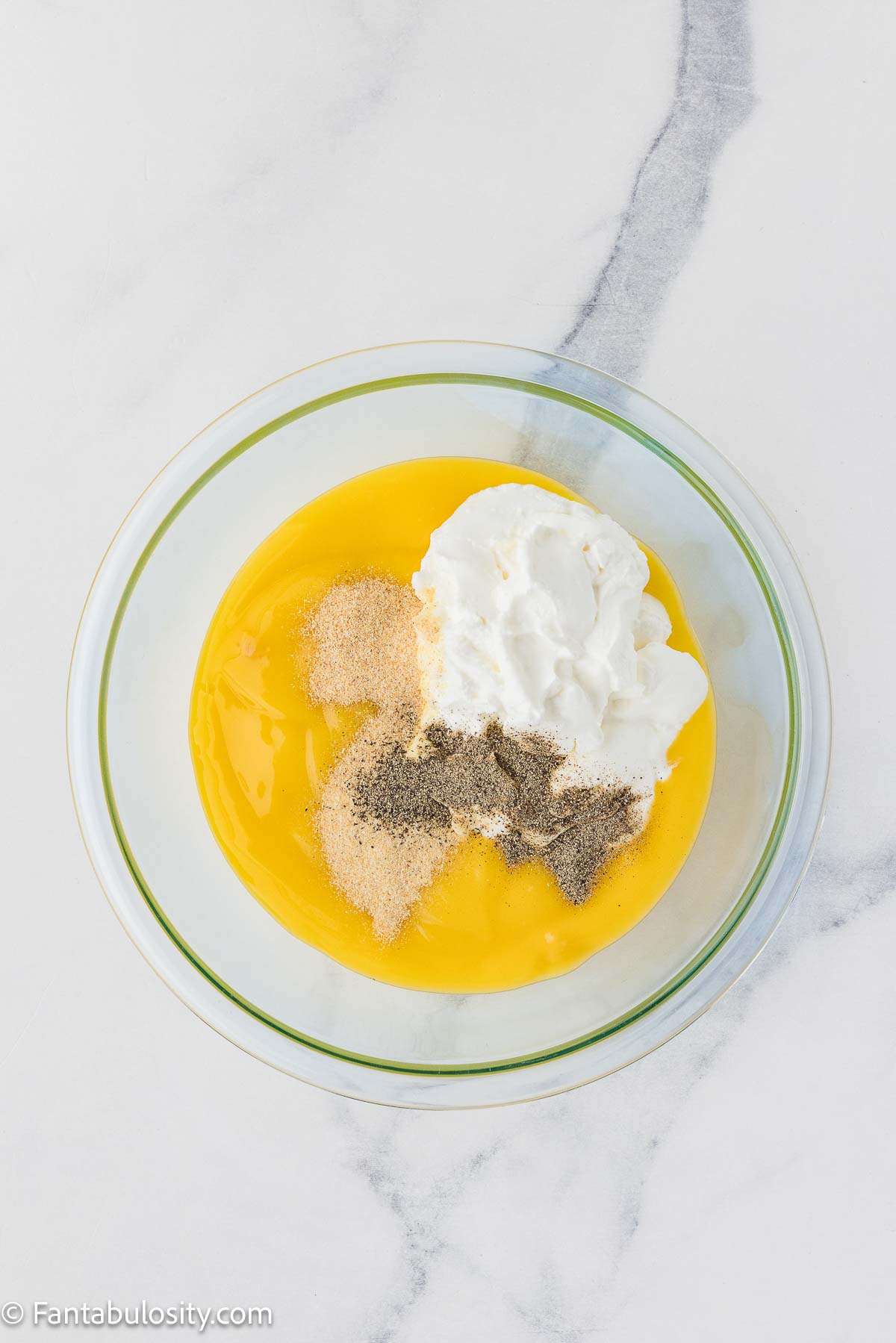 Soup, sour cream and spices in mixing bowl for filling of casserole.