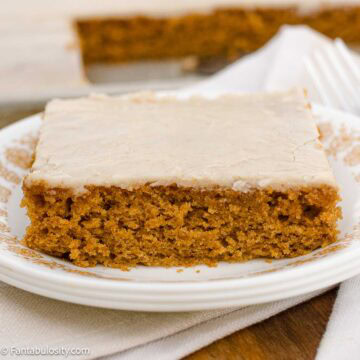 A slice of pumpkin sheet cake with brown butter frosting on a vintage plate.