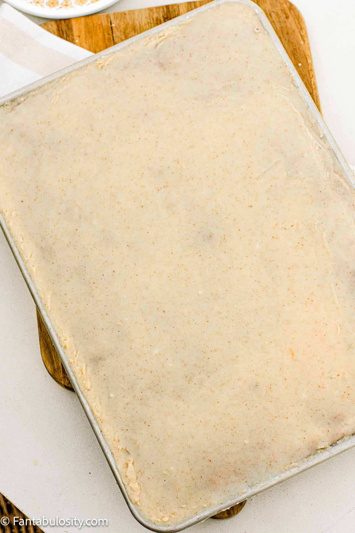A whole pumpkin sheet cake in a jelly roll pan topped with brown butter frosting.