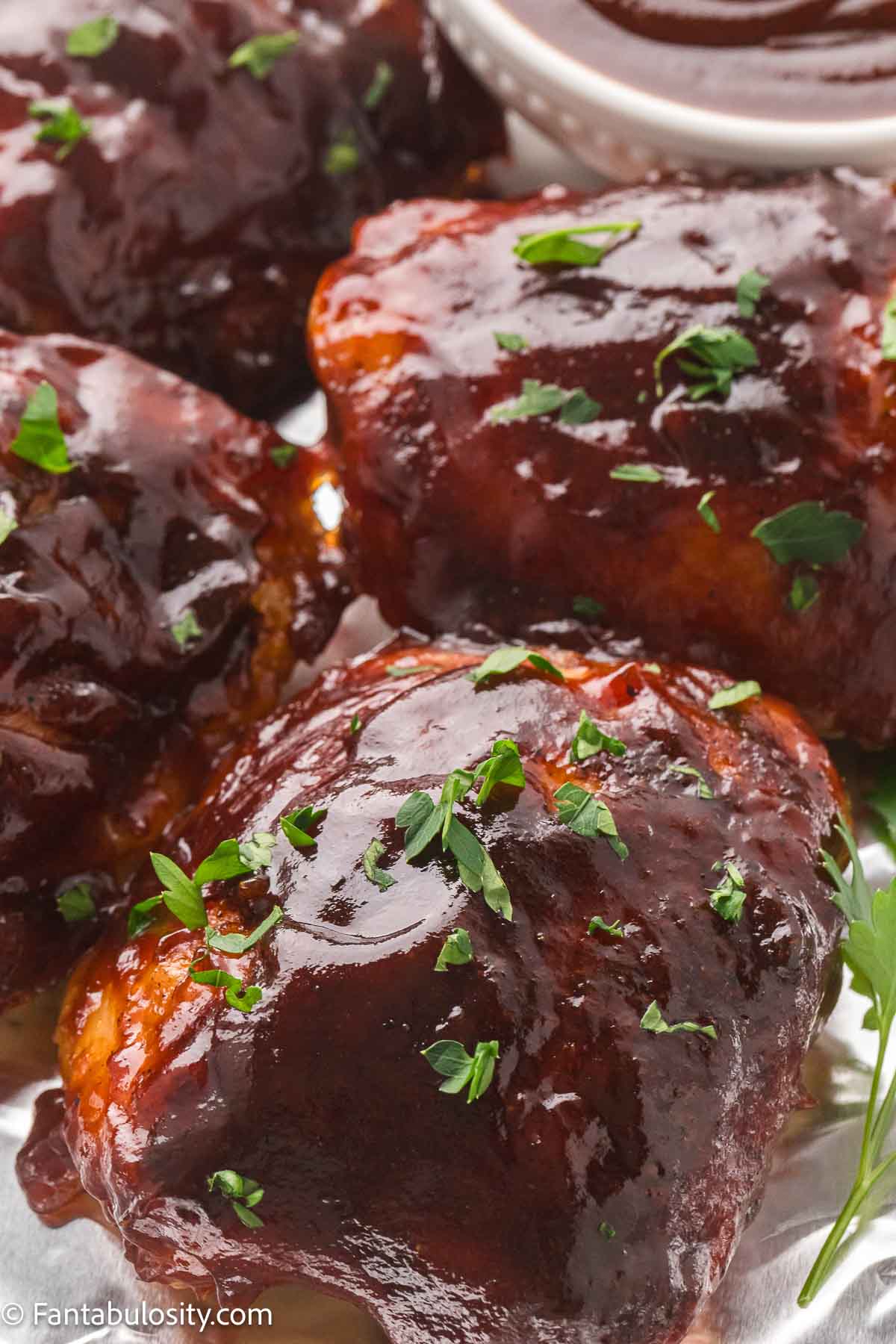 Close up of the sticky caramelized glaze on baked BBQ chicken thighs.