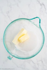 Butter and sugar in a glass mixing bowl before creaming together.