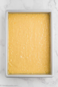 Coconut cake batter spread in a 9x13 baking pan.