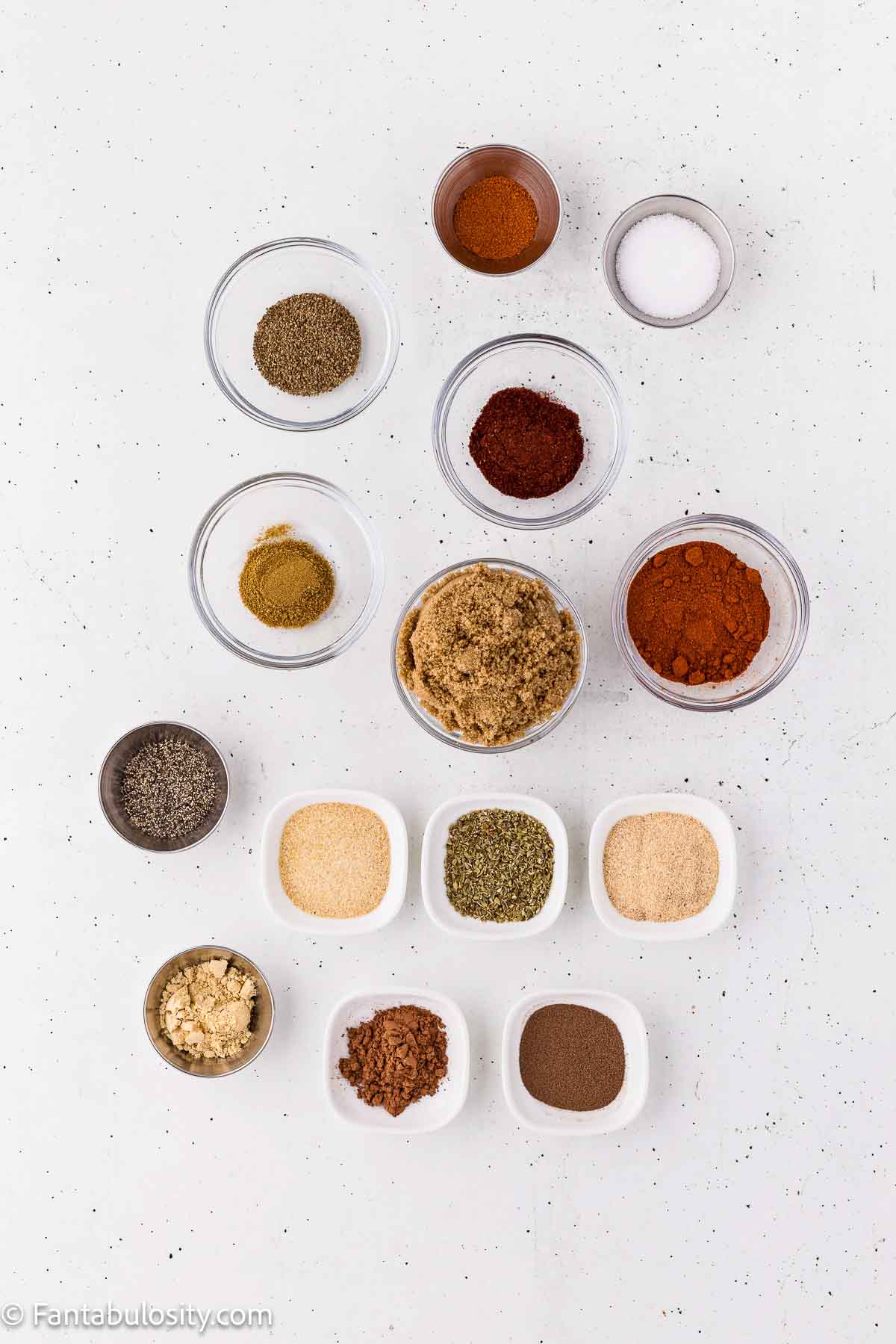 Small bowls of brown sugar, smoked paprika, and spices for homemade rib rub
