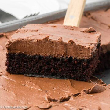 Slice of chocolate mayonnaise cake with a thick layer of chocolate frosting lifted from the pan.