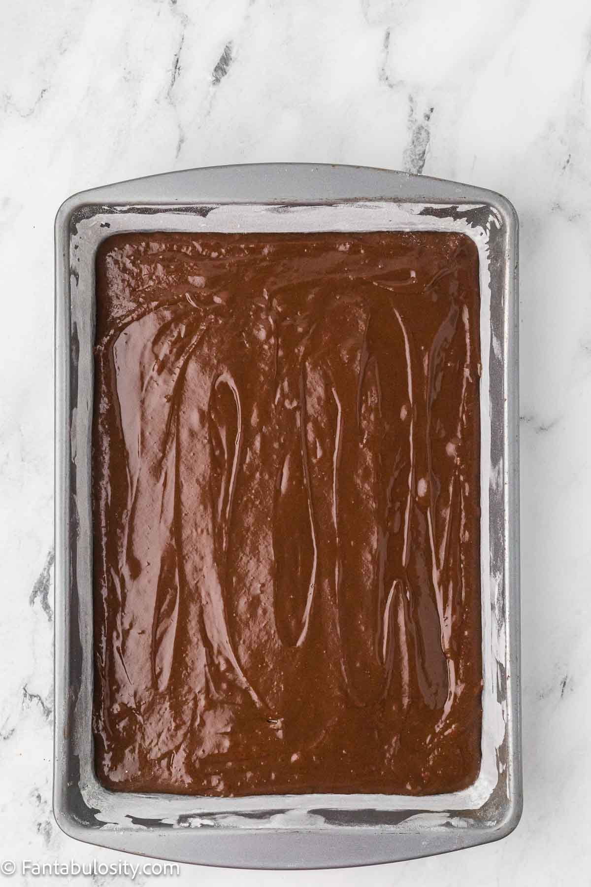 Chocolate mayonnaise cake batter spread in a rectangular baking pan.
