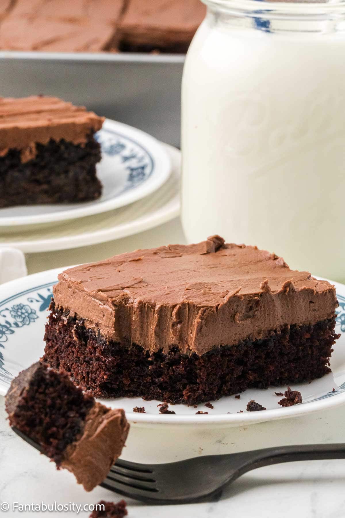 Slice of chocolate mayonnaise cake with chocolate buttercream and a bite on a fork.