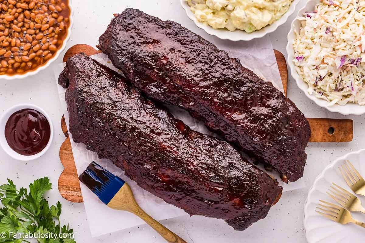 Oven baked ribs served with baked beans, coleslaw, and potato salad
