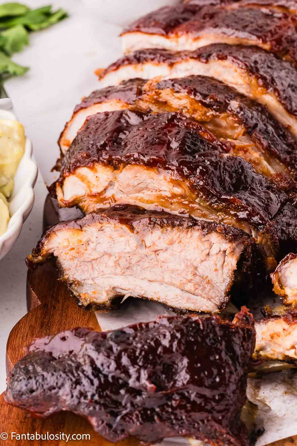 Close up of sliced baby back ribs showing meat pulling away from the bone