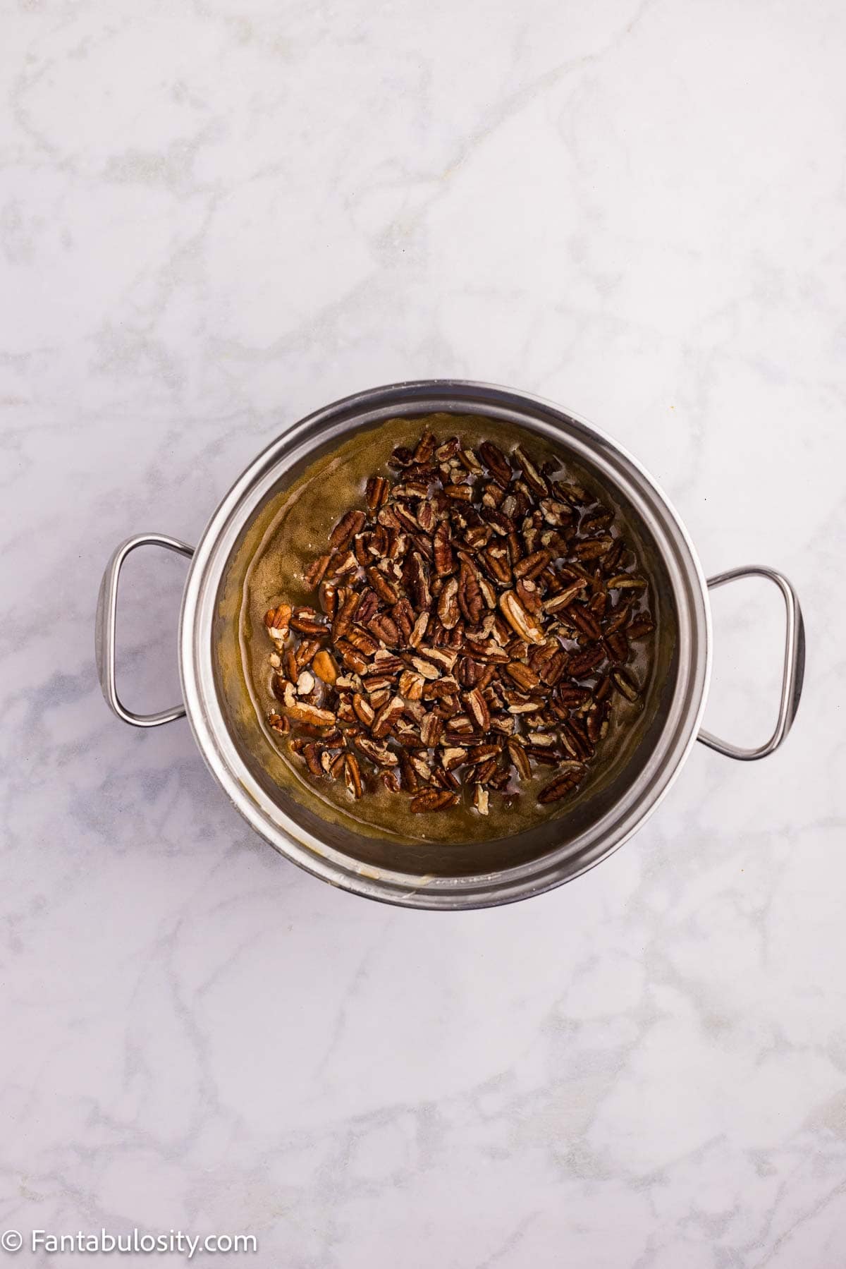 Chopped pecans mixed into the brown sugar topping in a saucepan.