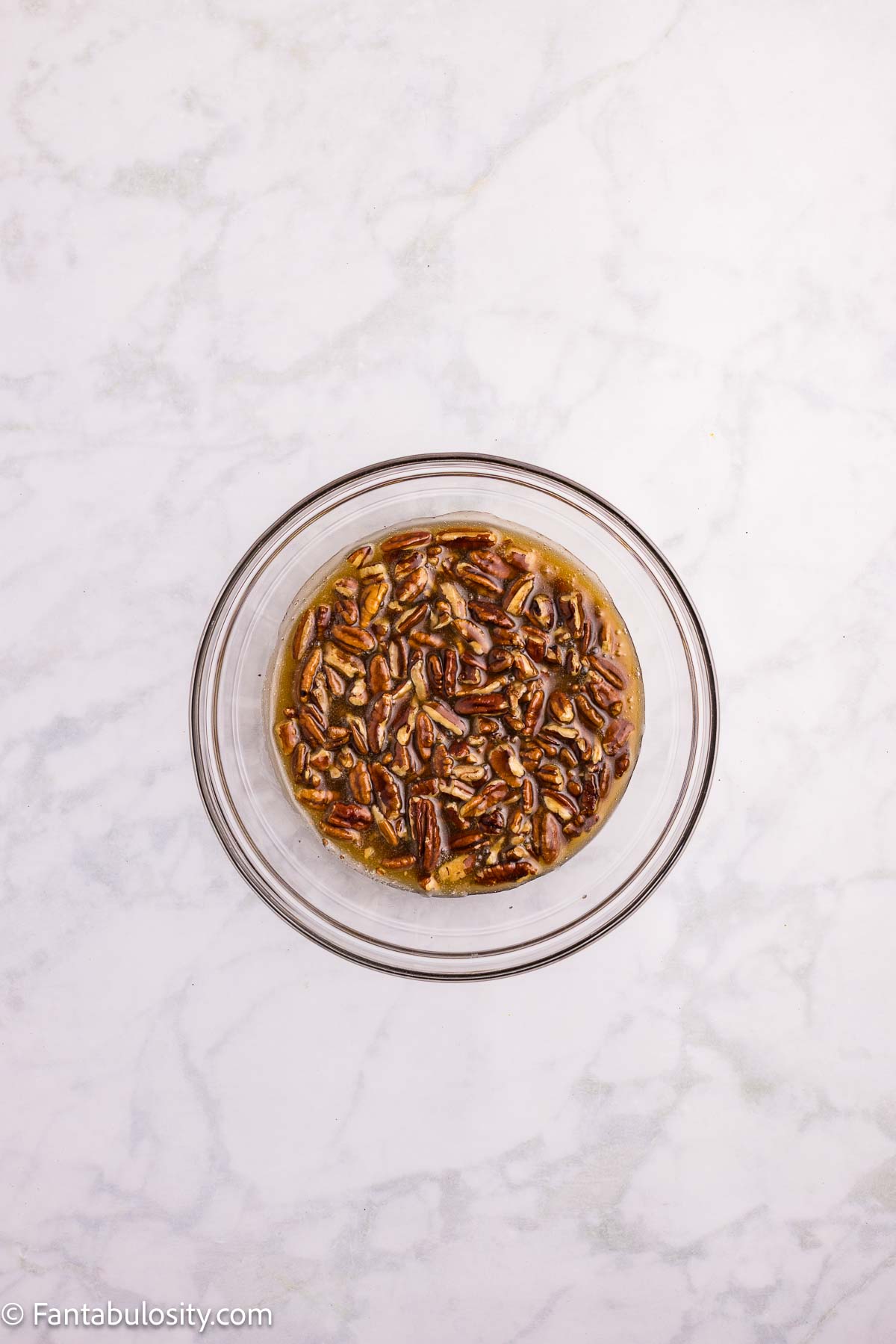 Pecan topping in a glass bowl, ready to cool before layering.