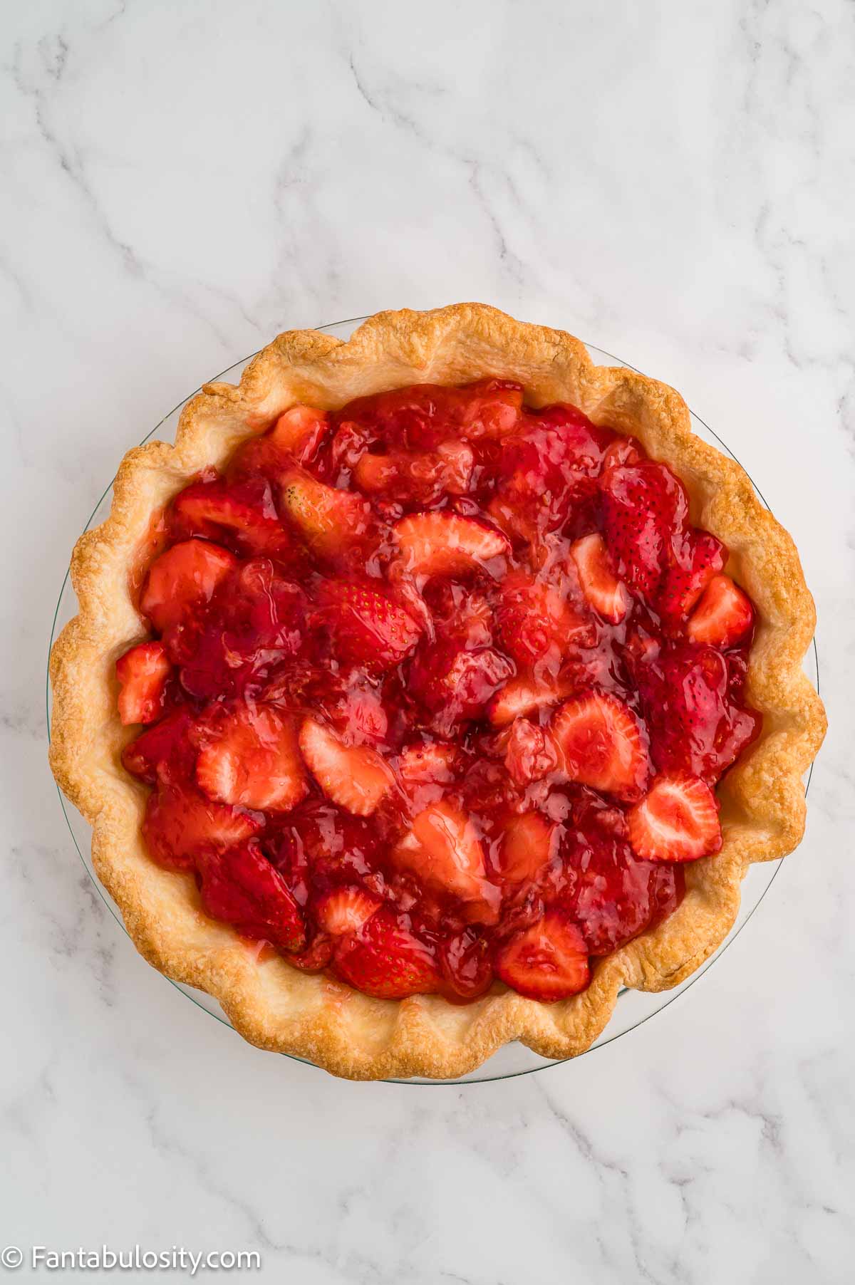 Strawberry filling spread into a baked pie crust.