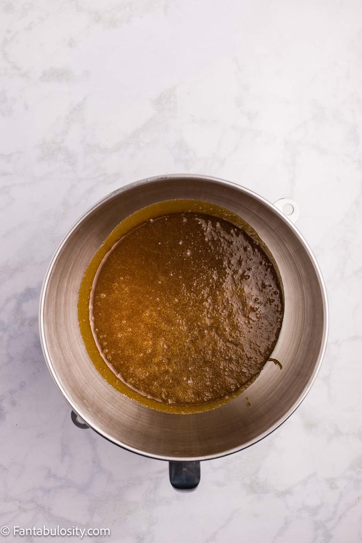 Cooked brown sugar mixture resting in a stainless steel mixing bowl.