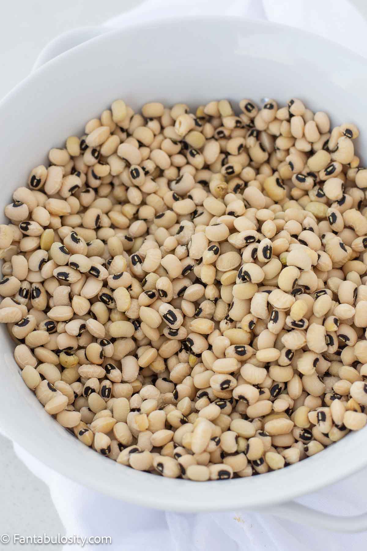 Dried black eyed peas in a white colander.