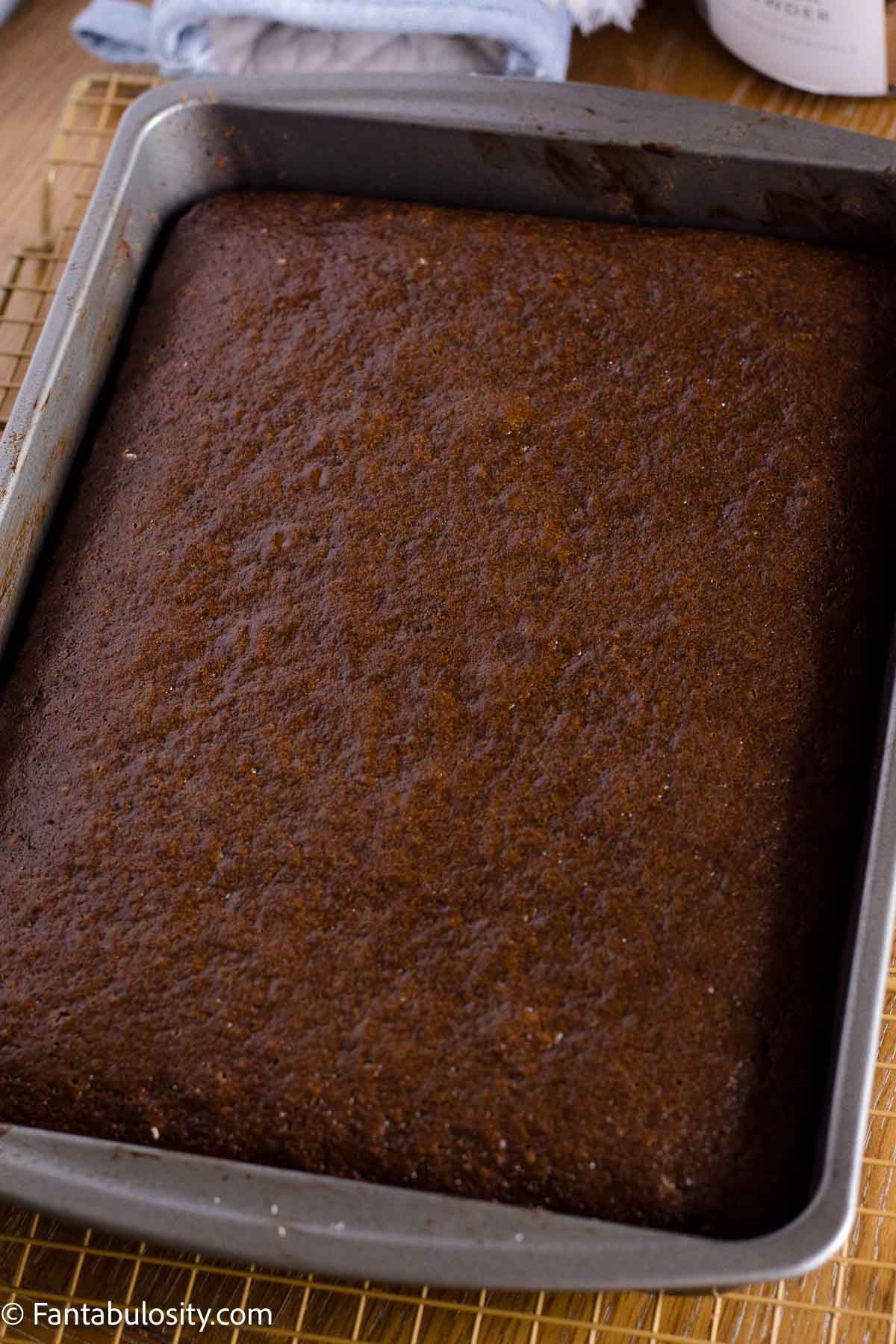 Baked chocolate mayonnaise cake with a flat top cooling in the pan.