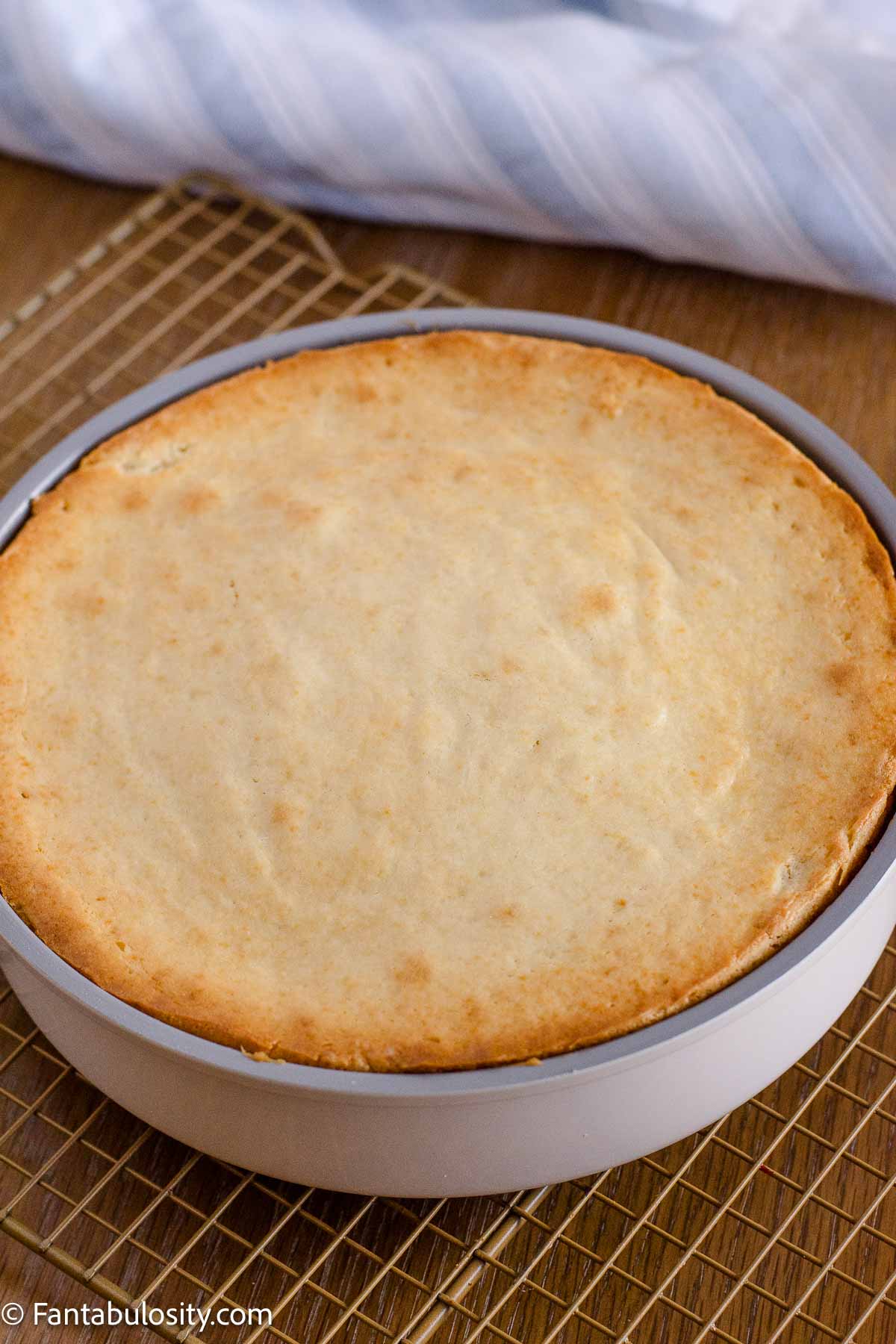 Golden cake after baking in a round metal pan