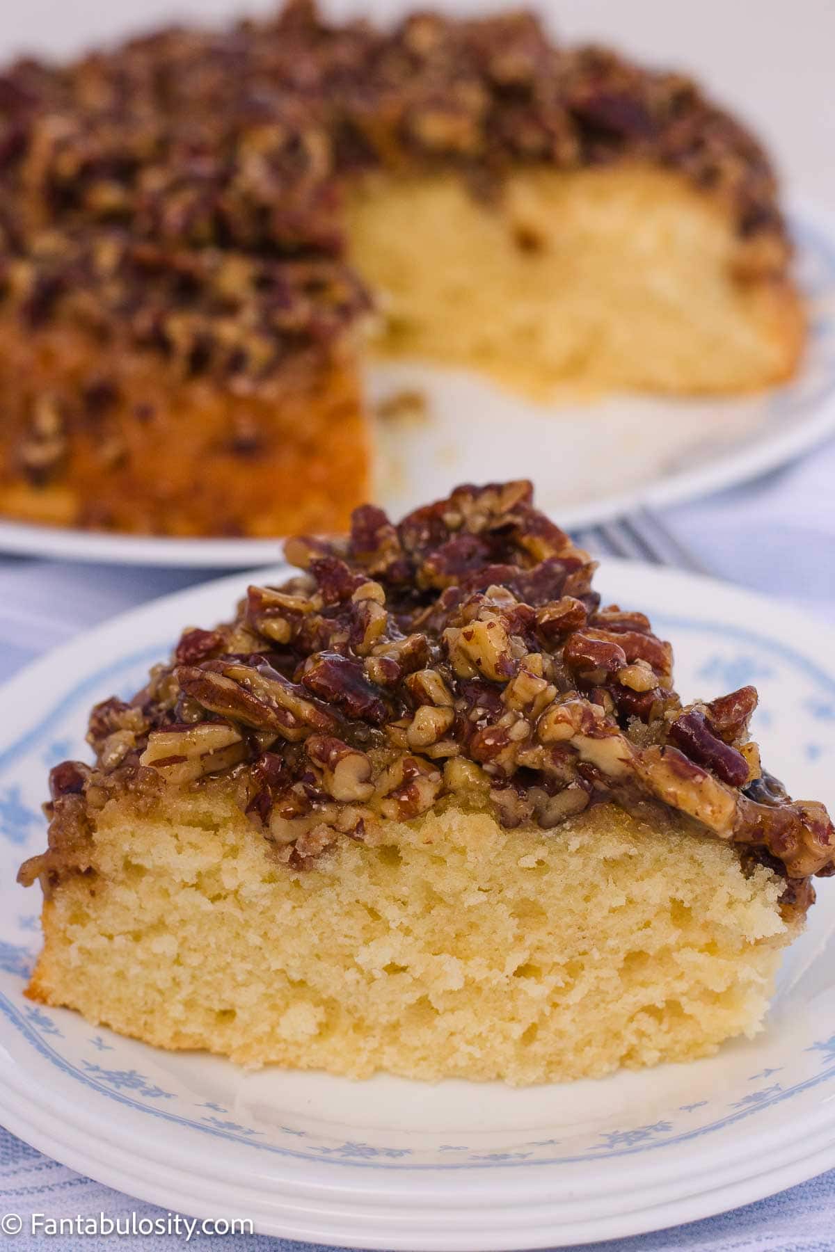 Slice of pecan upside down cake showing the vanilla cake and pecan topping