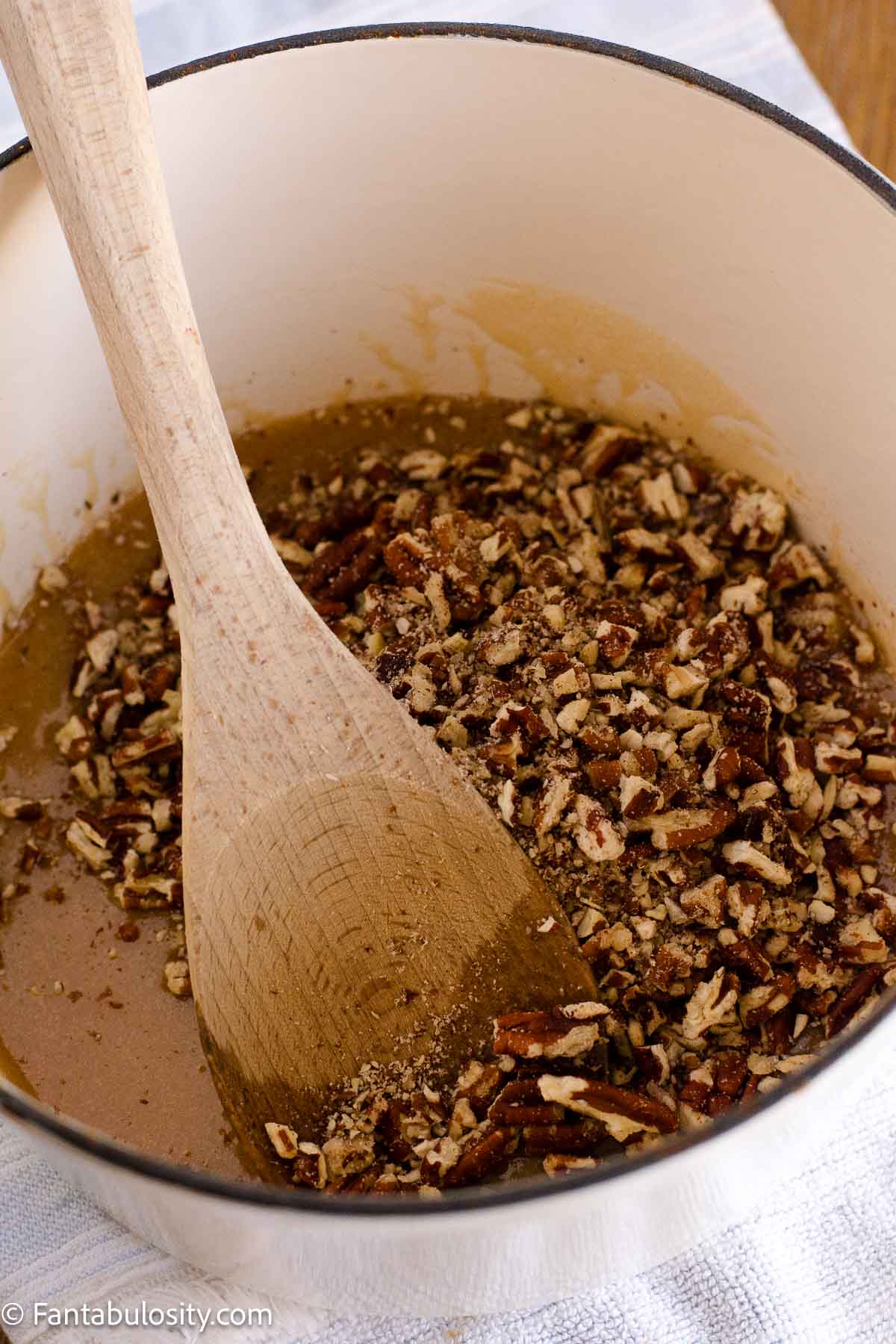 Chopped pecans stirred into the brown sugar topping in a saucepan