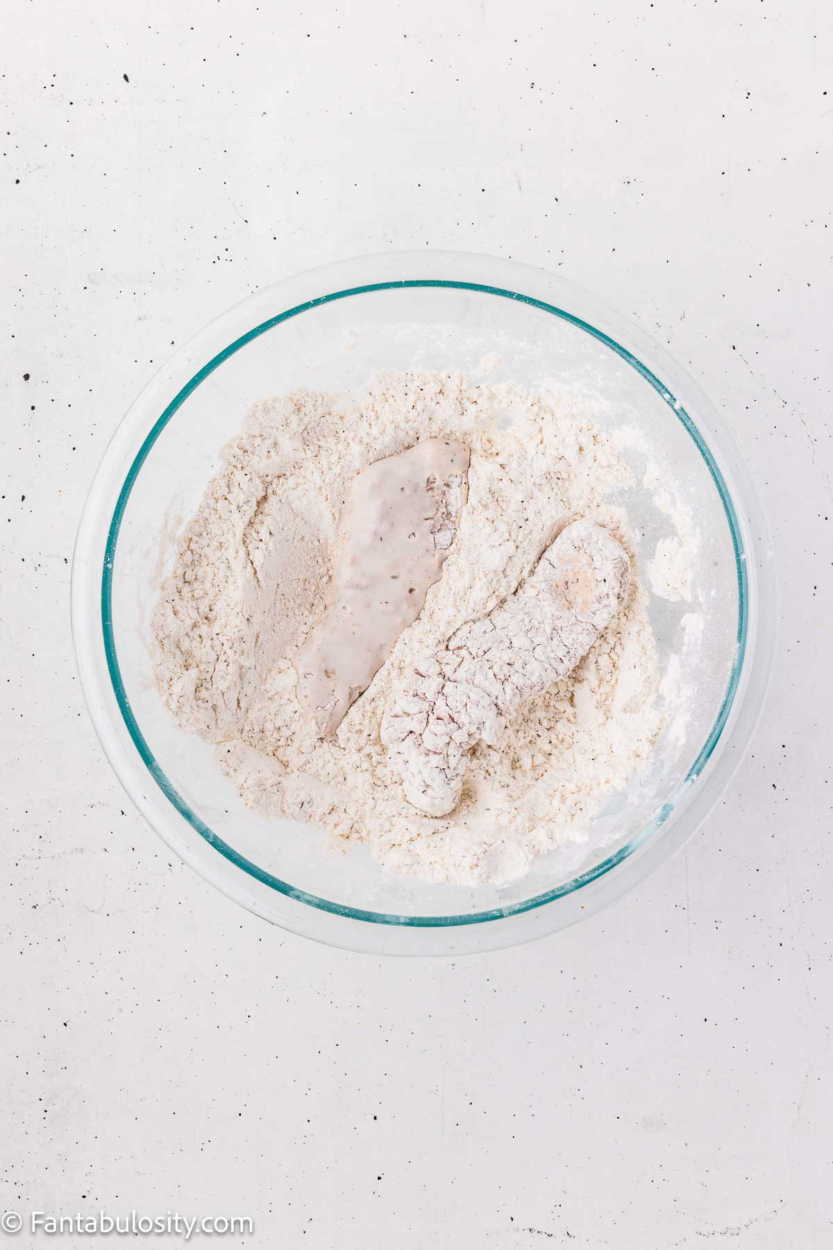 Steak strips covered with a second coating of seasoned flour.