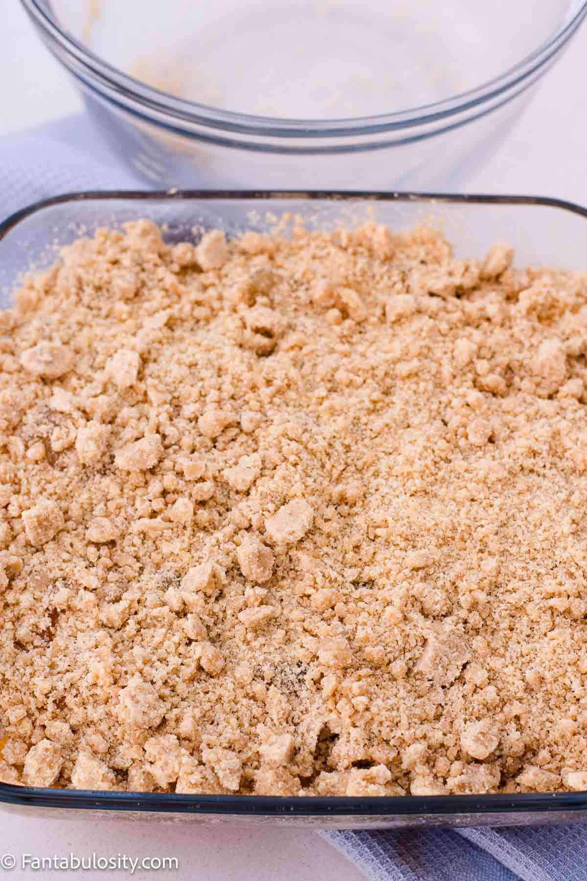 Unbaked crumble topping scattered evenly over the apple filling.